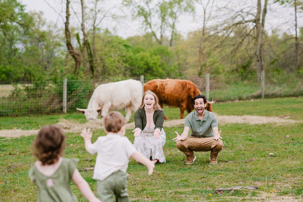 Two year old twins run toward their parents in a farm field during their family photography session with Christy Rice Photography at Cooper's Knoll Farm in Pataskala, Ohio