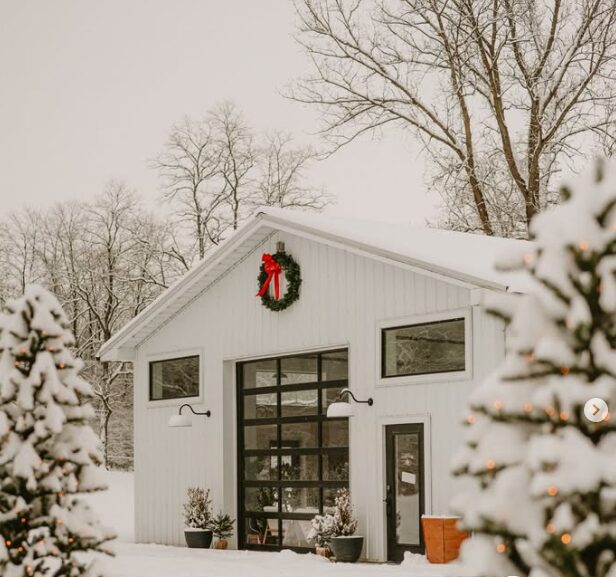 White barn decorated for Christmas with a pine wreath at Humble + Pine Studios in Pataskala, Ohio. 